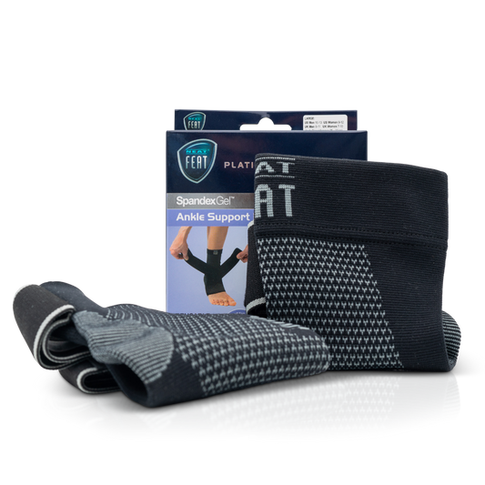 Platinum Series Spandex Gel Ankle Support Brace. The image shows the packaging box in the background, with two grey and black ankle braces displayed in the foreground. One brace is standing upright, while the other is lying down, showcasing the product's design and support features.